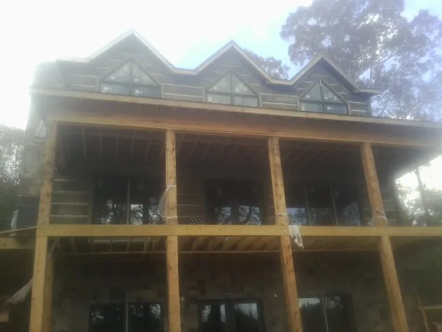 Dormers and porch framing on a large log home under construction — Roof Coating work by our crew in La Pine