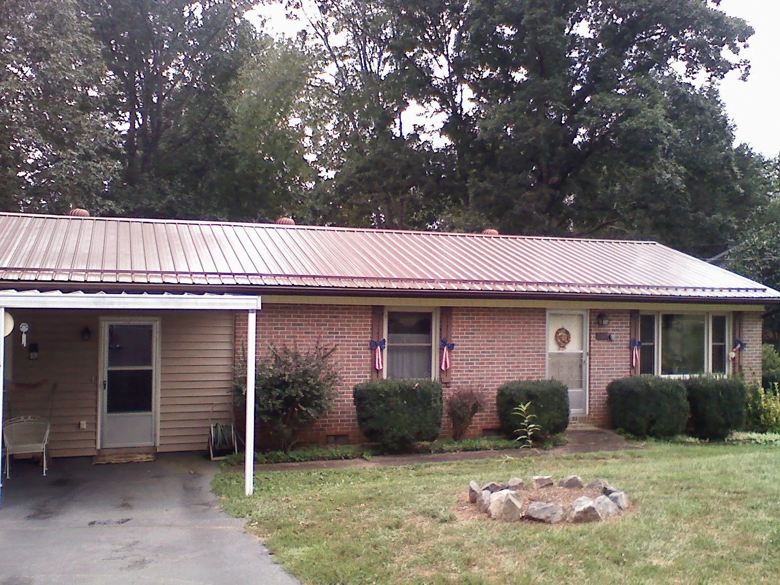 Bronze metal roof and carport on a brick ranch home — Roof Repair work by our crew in La Pine